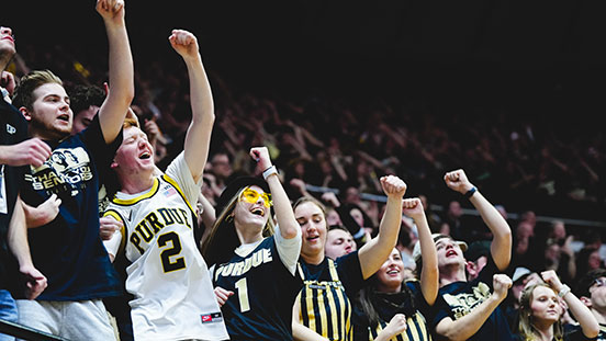 Purdue University students cheering at sporting event.